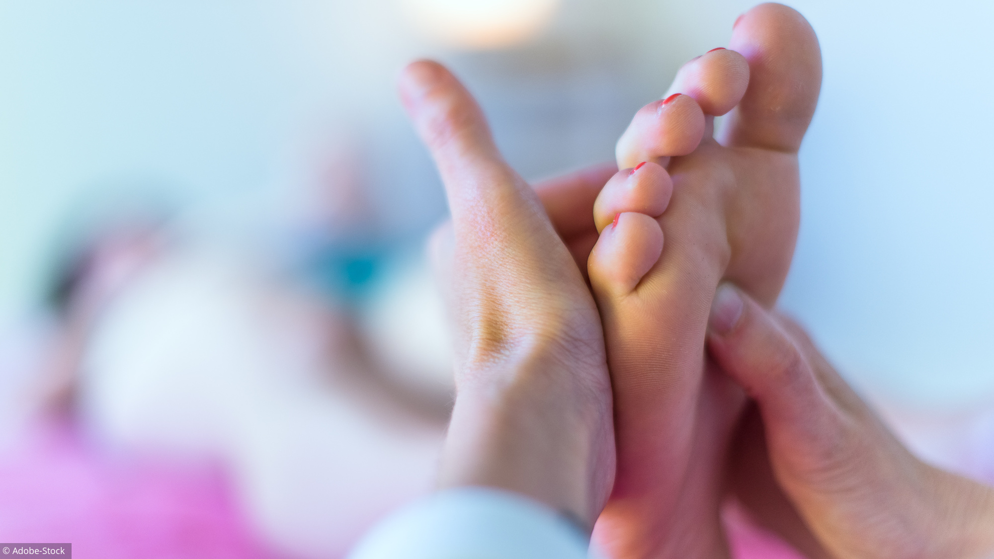 Therapist's hands massaging female foot