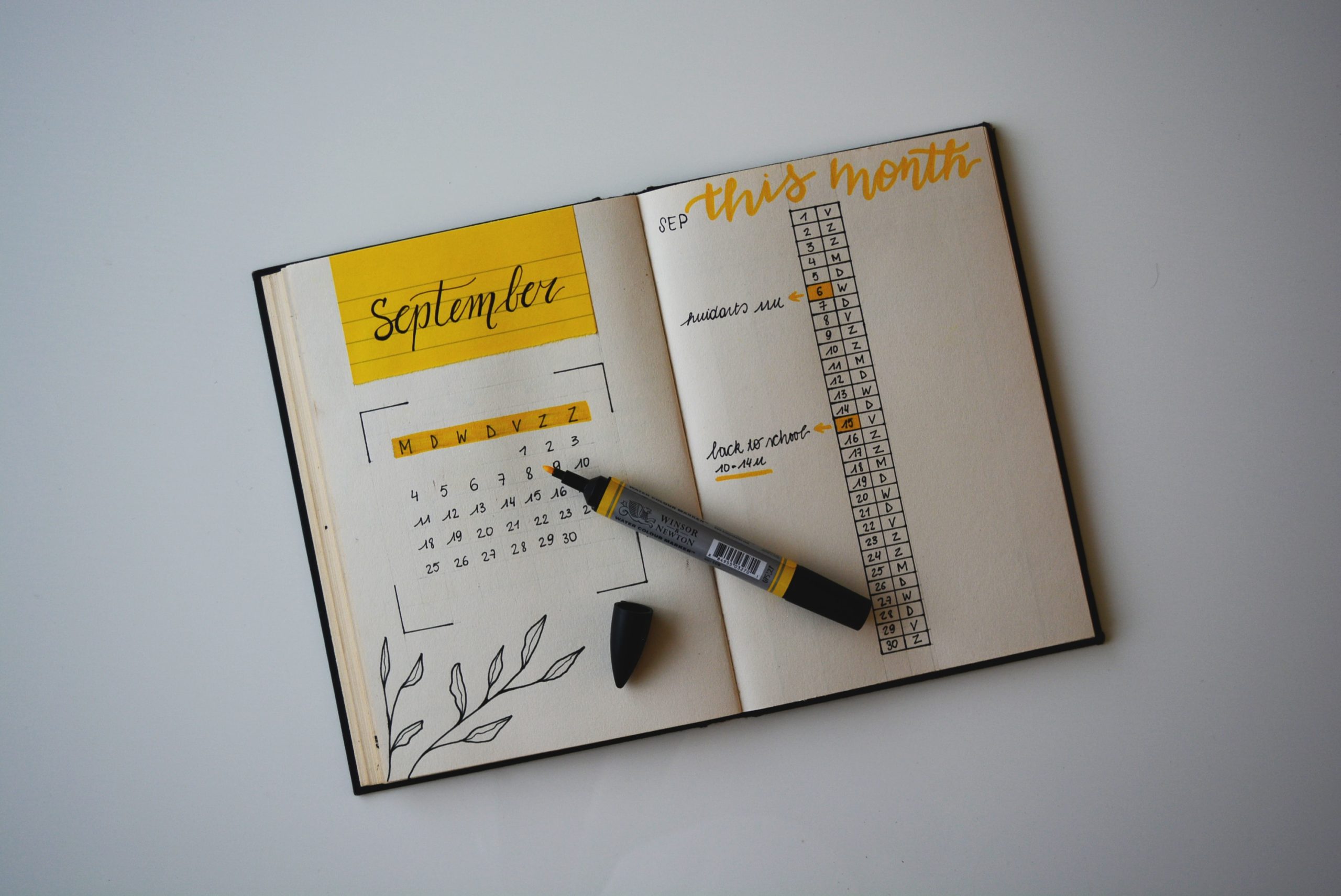 Photo par Estée Janssens white planner with pen on top